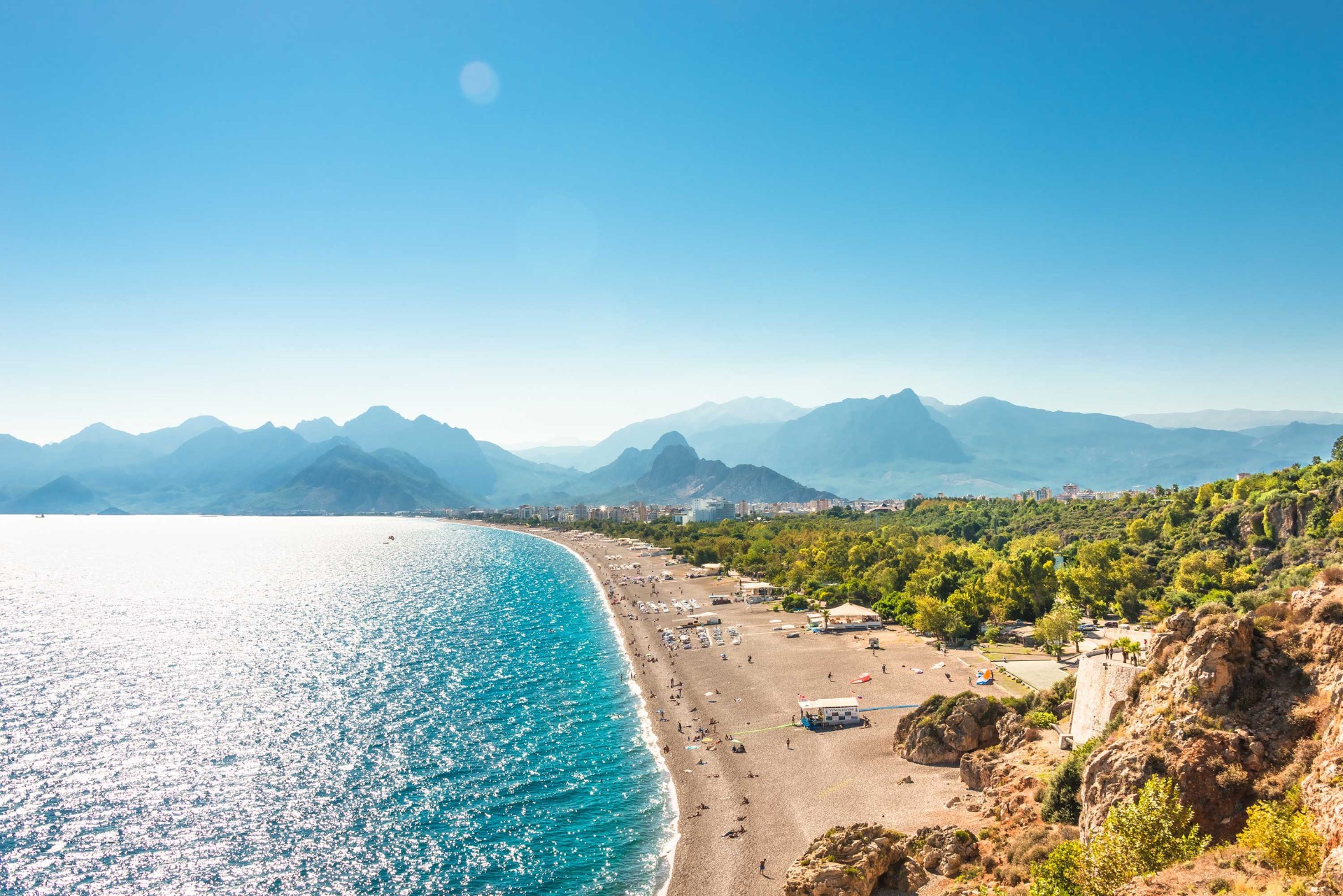 Türkisfarbener Strand mit Bergen im Hintergrund